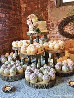 a table topped with cupcakes covered in frosting next to a brick wall