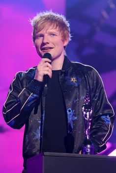 a man standing at a podium holding a microphone