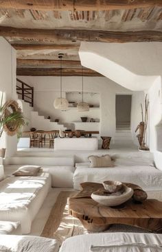 a living room filled with white furniture and lots of windows