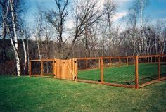 a fenced in area with grass and trees