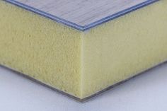 a close up view of a piece of yellow foam on a white surface with silver trim