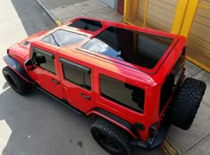 a red vehicle is parked on the side of the street