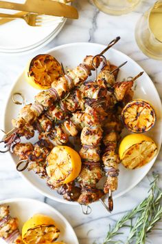 grilled chicken and vegetable kabobs on a white plate with rosemary garnish