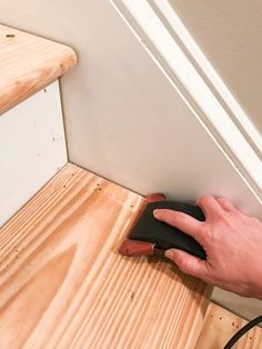 a hand with a mouse on top of a wooden floor next to a stair case