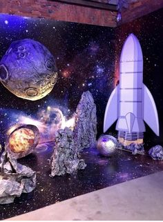 an image of a space themed room with rockets and planets on the wall in front of it