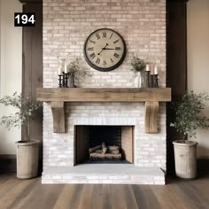 a fireplace with a clock above it and some potted plants on the mantel