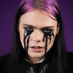 a woman with black and white makeup on her face