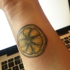 a small lemon tattoo on the wrist