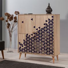 a wooden cabinet with geometric designs on the front and sides, sitting in a living room