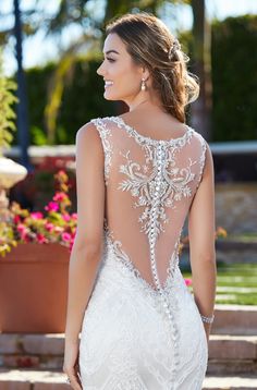 a woman in a wedding dress with an open back and beading on the top