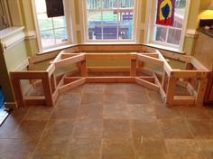 a kitchen area with wooden benches and windows