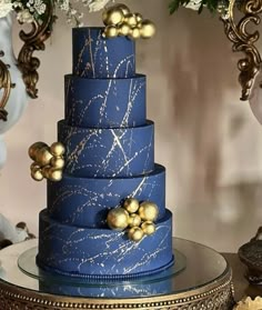 a blue and gold wedding cake on a table