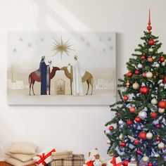 a christmas tree with presents under it and a nativity scene on the wall behind it