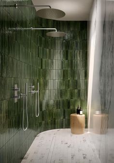 a bathroom with green tiles and a white tub in the corner, next to a shower head