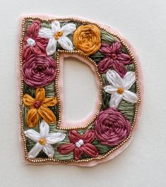 the letter d is decorated with flowers and beads