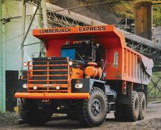 an orange dump truck parked in front of a building