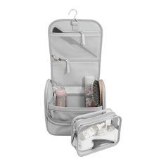 an open travel bag filled with cosmetics and other personal care items on a white background