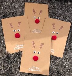 four brown envelopes with reindeer faces and red noses on them sitting on a carpet