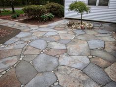 a stone walkway in front of a house