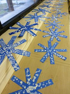 blue snowflakes are laid out on the floor in front of a large window