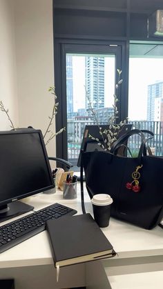 a black bag sitting on top of a desk next to a computer monitor and keyboard