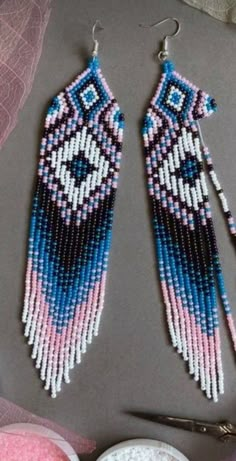 two pairs of beaded earrings sitting on top of a table