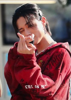 a young man holding a cell phone up to his ear with the words eyes on me written in front of him