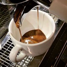 coffee being poured into a white cup