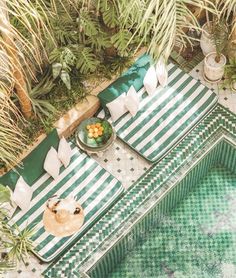 an aerial view of a table with food on it next to a pool surrounded by palm trees