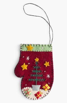 an ornament with a christmas tree hanging from it's side on a white background