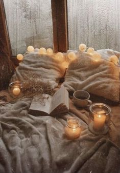 a bed with candles and books on it