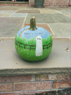 a painted pumpkin sitting on top of a sidewalk