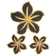 This rare signed couture set of pave-crystal and gold-plated brooch and earrings from the Art Deco period is marked in the manner of one-off costume jewelry commissioned by Gabrielle "Coco" Chanel around 1930. "Made In France" is stamped on the hinge of one of the earliest kind of French wire-clip fasteners for earrings. The intricate flowerhead designs distinctly set with satin fabric suit jewelry by Corsican parurier Lina Baretti, who created one-of-a-kind works for Chanel since at least 1930 that often included black fabric after the fashion designer had become internationally famous for her "little black dresses". Beyond the distinct country-of-origin stamp on our set, black five-petal camellias are characteristic of Chanel. Baretti later made gold-edged unsigned earrings reminiscent o Suit Jewelry, Valentino Couture, Elsa Schiaparelli, Multi Pendant, Chanel Vintage, Art Deco Period, French Wire, Gold Set, Jewelry Vintage