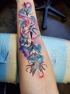 a woman's arm with a watercolor tattoo design on the left side of her arm