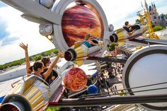 people ride on roller coasters at an amusement park