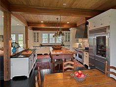 a large kitchen with an island table and chairs next to the stove, oven, microwave and refrigerator