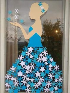 a window decorated with blue and white snowflakes, stars and a silhouette of a woman