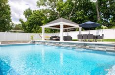 a pool with chairs and an umbrella next to it