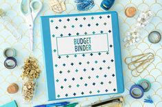 a binder with the words budget binder on it surrounded by craft supplies and scissors