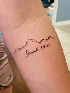 a tattoo on the arm that reads, teach 5110 with mountains in the background