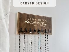 a wooden sign that says pray hope and do not worry with beads hanging from it