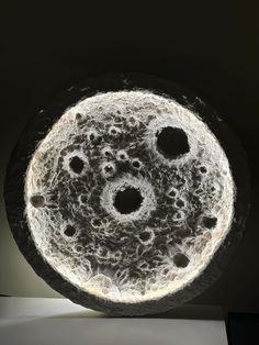 a black and white photo of a circular object with holes in it's center