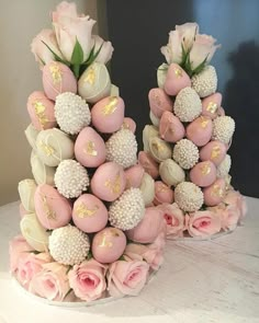 two vases filled with pink and white flowers on top of a table