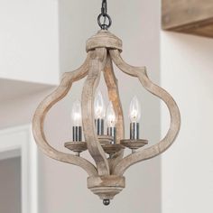 a wooden chandelier with three lights hanging from it's center and two small candles