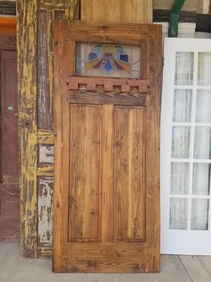 an old wooden door with stained glass in the top and bottom part, next to another wood door