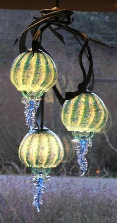 three glass balls hanging from a tree branch