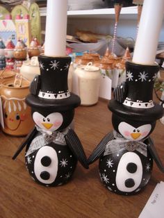 two black and white penguin candlesticks sitting next to each other on a table