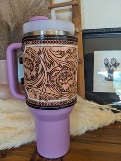 a purple coffee cup sitting on top of a wooden table next to a framed photo