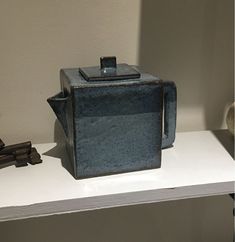 a teapot sitting on top of a white shelf