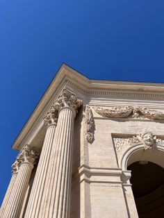 an old building with columns against a blue sky